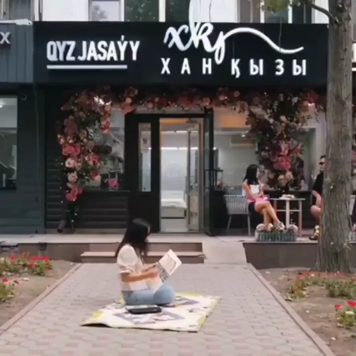 The Xan Kyzy boutique facade with QYZ JASAÝY and Хан Қызы signage and a flower-covered entrance